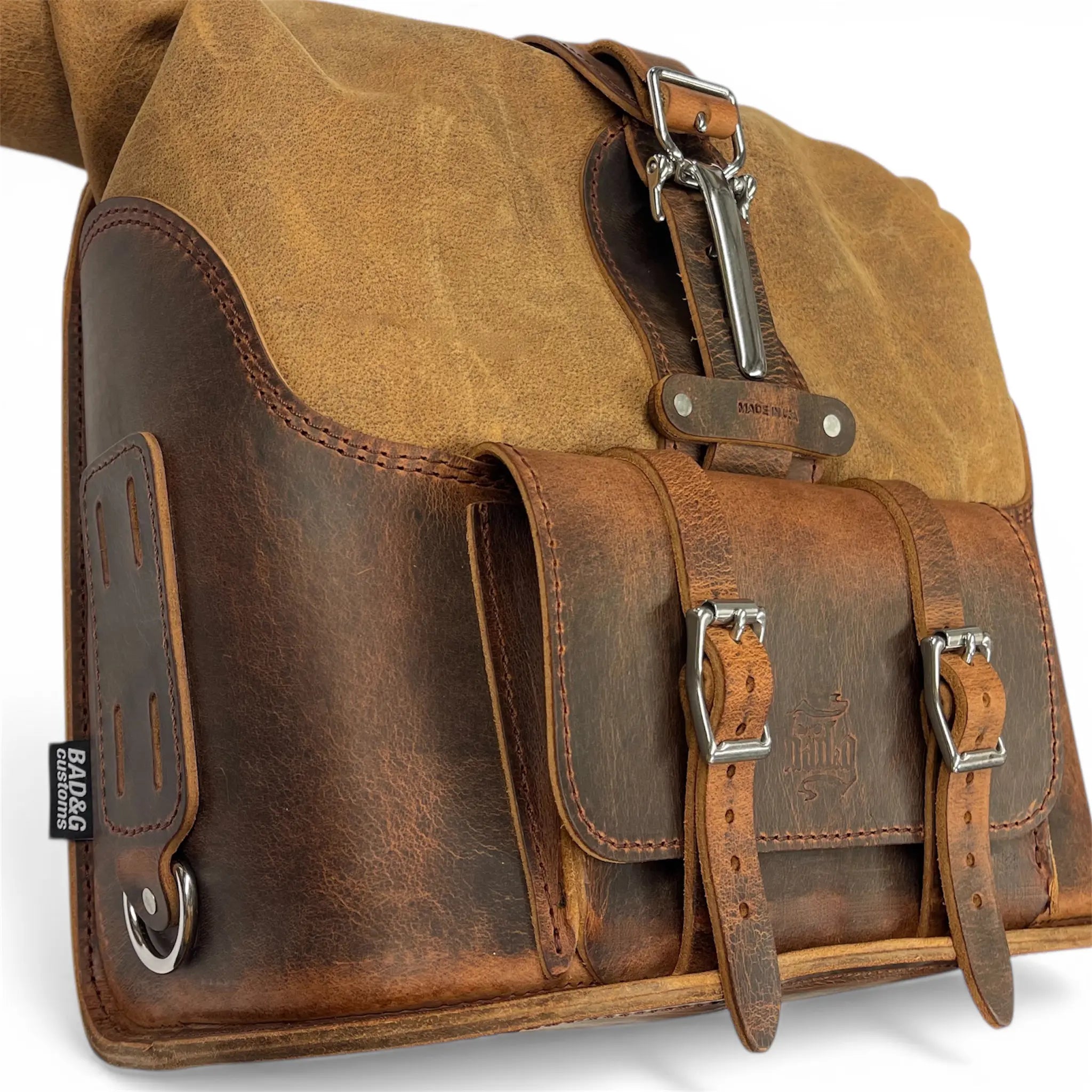 Brown leather satchel bag with metal buckles on a white background